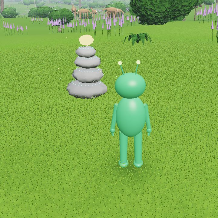 A cairn of stacked grey stones with a gold capstone in a spring meadow, beside the green alien.